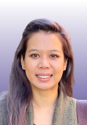 Smiling person with purple background.