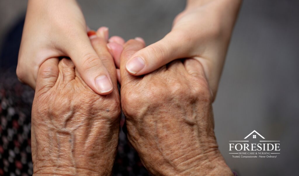 Young hand comforting elderly hands, Foreside Home Care.