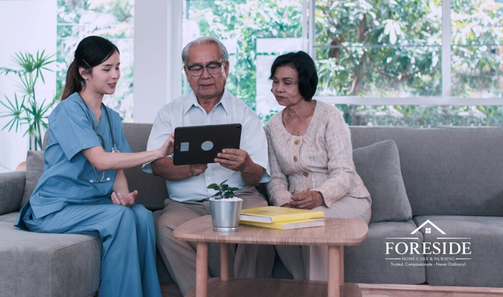 Nurse showing tablet to elderly couple on couch.