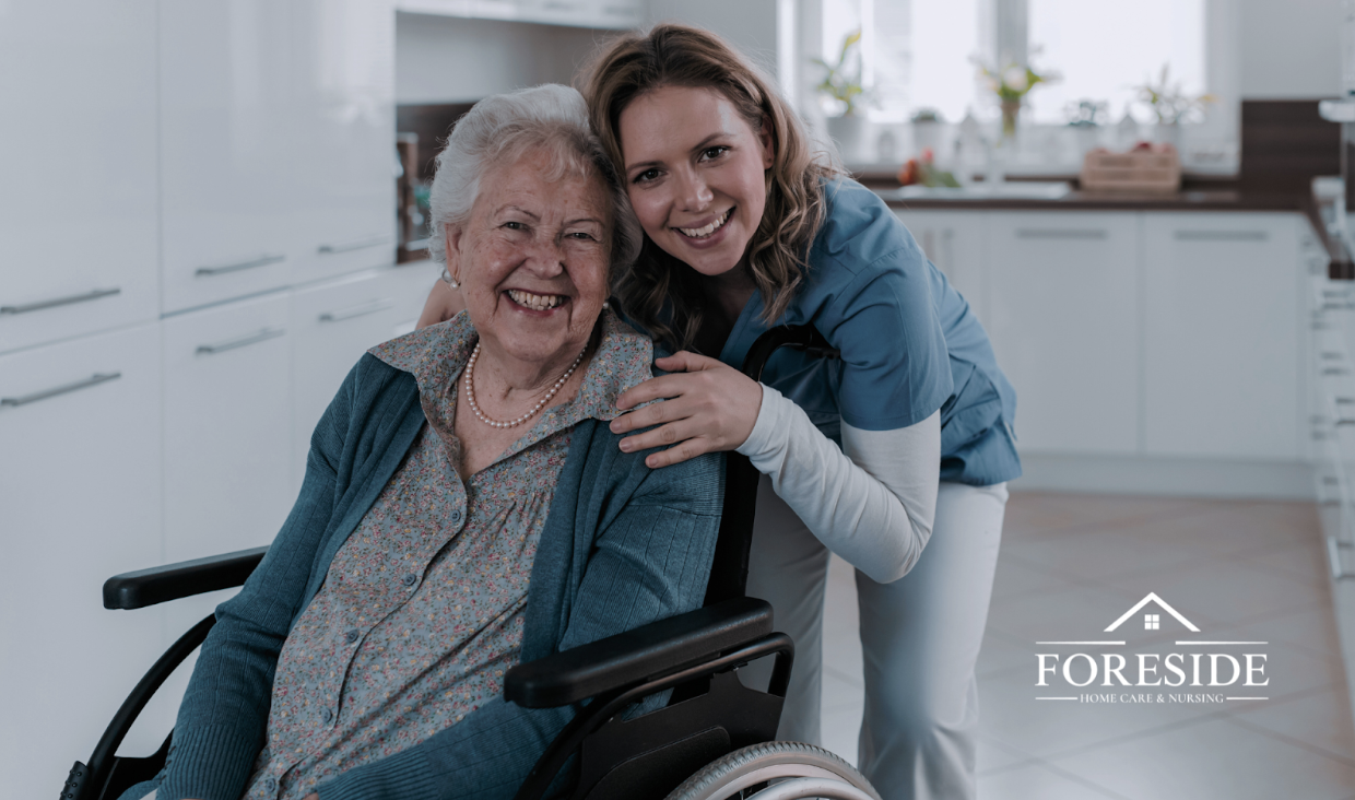 Caregiver smiles with elderly woman in wheelchair.