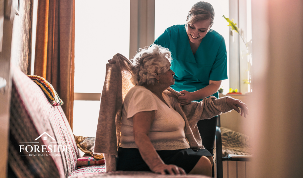 Smiling caregiver assisting elderly woman at home.